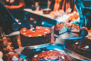 A shop window display of chocolate cakes and tarts